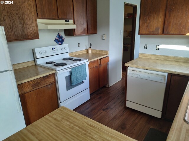 kitchen featuring white appliances and dark hardwood / wood-style flooring