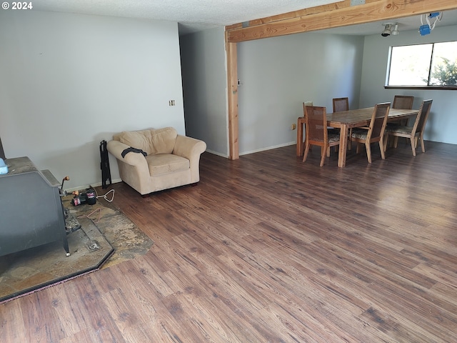 living room with a textured ceiling, a wood stove, and dark hardwood / wood-style flooring