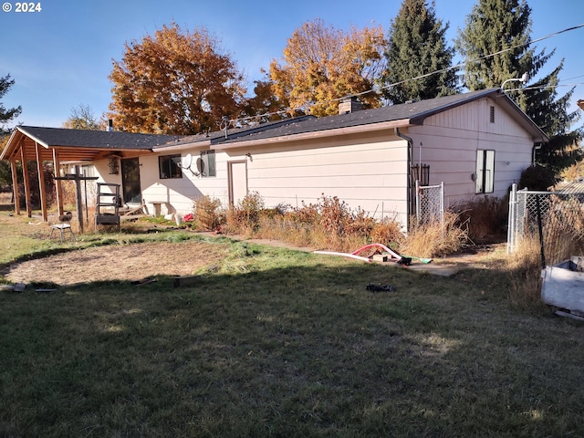 rear view of property with a lawn