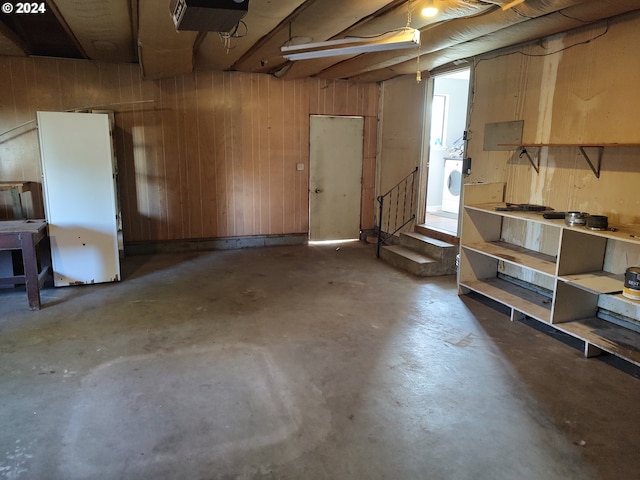 basement featuring wooden walls