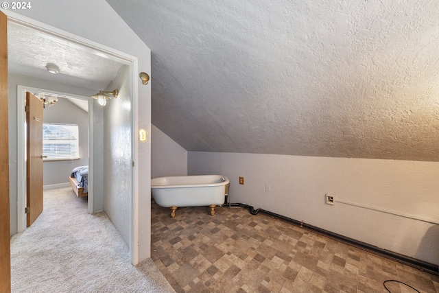 bathroom featuring a textured ceiling and vaulted ceiling