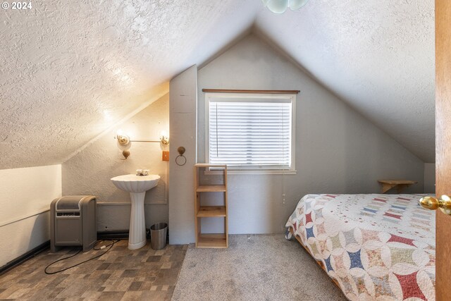 bedroom featuring a textured ceiling and lofted ceiling