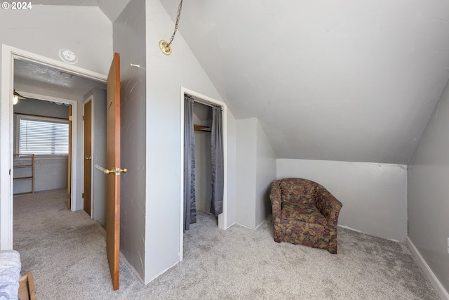 living area with light colored carpet and vaulted ceiling