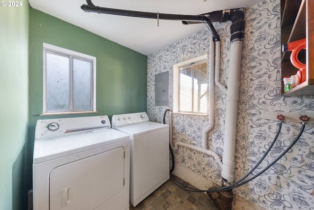 laundry area featuring electric panel, a wealth of natural light, and washing machine and clothes dryer