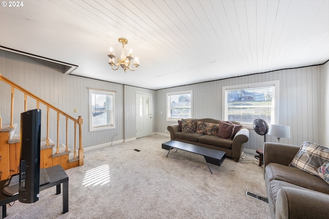 carpeted living room featuring a chandelier, wooden walls, and wooden ceiling