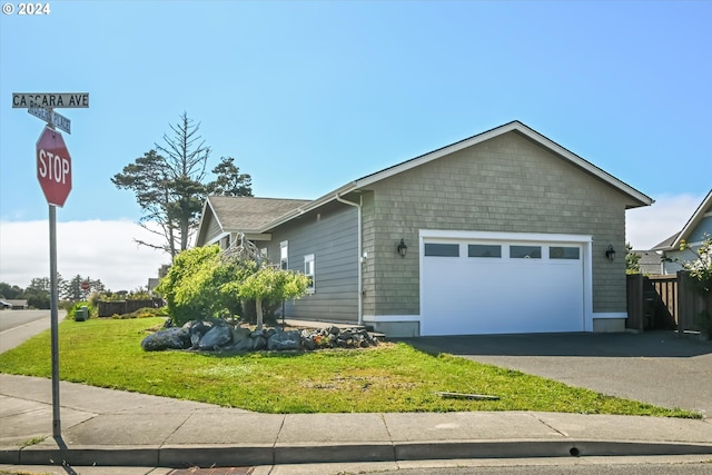 view of front of property featuring a front lawn and a garage