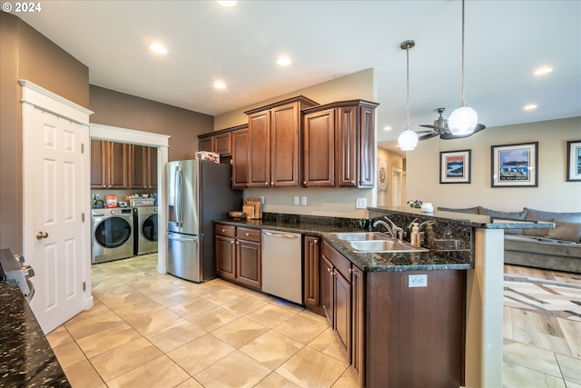 kitchen featuring pendant lighting, sink, ceiling fan, separate washer and dryer, and stainless steel appliances