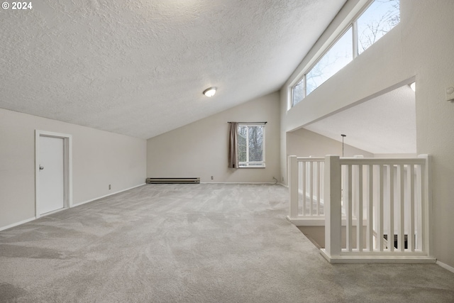 bonus room featuring a textured ceiling, light colored carpet, vaulted ceiling, and a baseboard heating unit