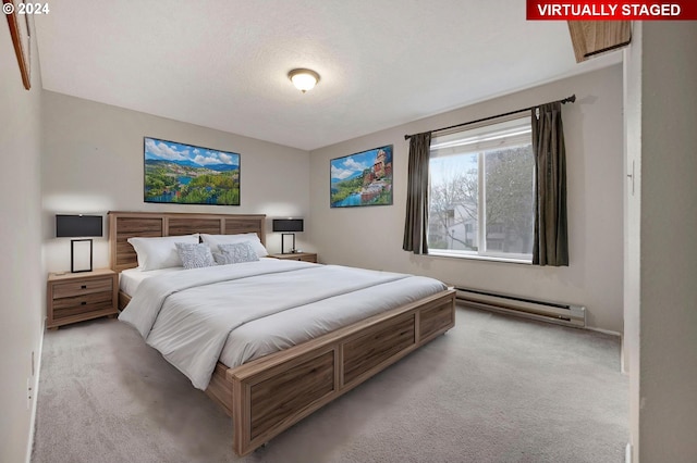 bedroom with a textured ceiling, a baseboard radiator, and light colored carpet