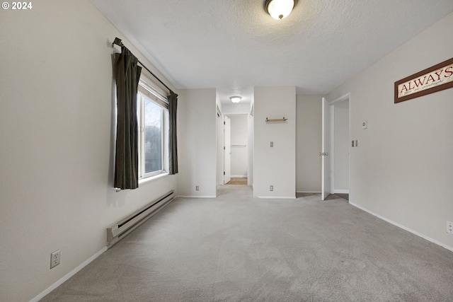 empty room with light carpet, a textured ceiling, and a baseboard radiator