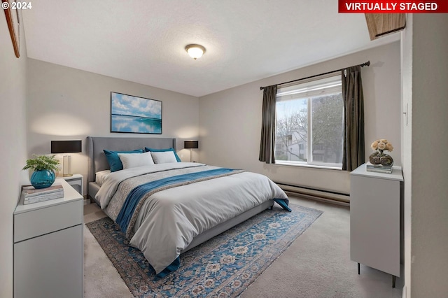 bedroom featuring a textured ceiling, light carpet, and a baseboard radiator