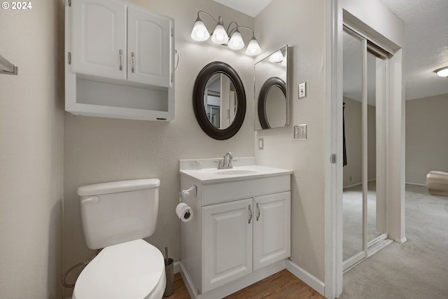 bathroom featuring vanity, a textured ceiling, and toilet