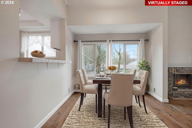 dining area featuring a fireplace and wood-type flooring