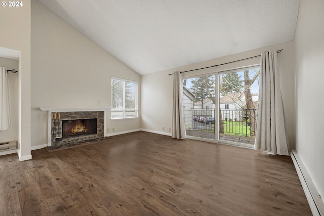 unfurnished living room featuring dark hardwood / wood-style floors, vaulted ceiling, a fireplace, and a baseboard heating unit