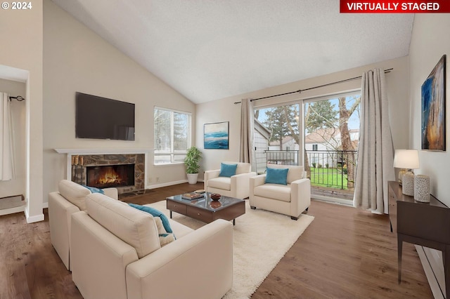 living room with a fireplace, hardwood / wood-style flooring, and lofted ceiling