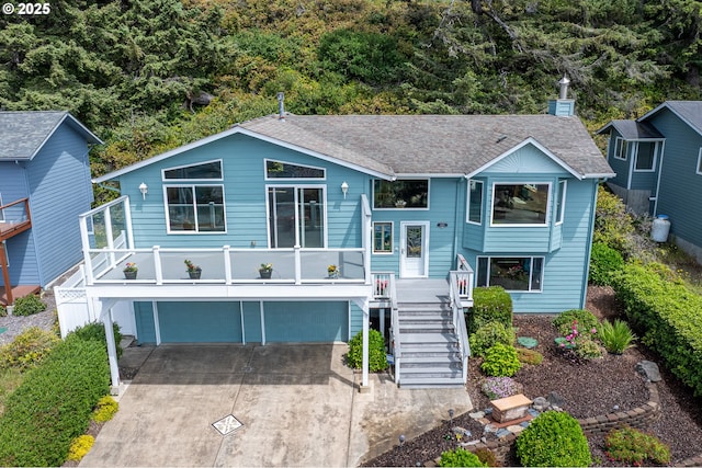 2105 NW Parker Ave, Waldport, OR 97394 - split foyer home featuring an attached garage, stairway, driveway, and a shingled roof