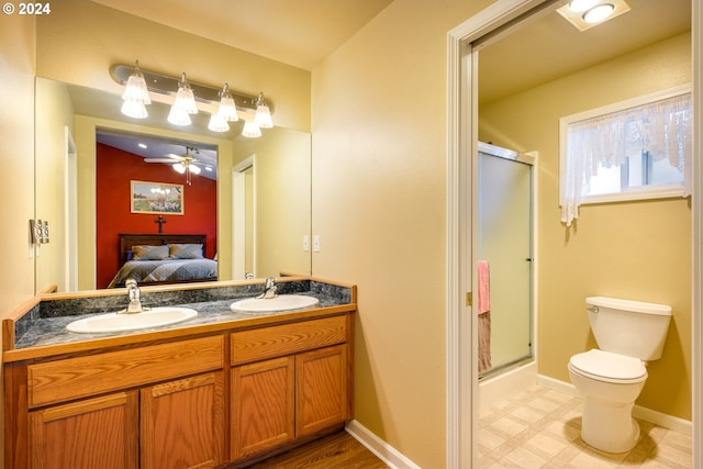 bathroom with vanity, toilet, a shower with door, and ceiling fan