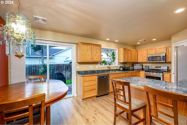 kitchen featuring a notable chandelier, light hardwood / wood-style floors, stainless steel appliances, and light brown cabinetry