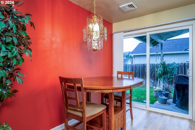 dining room featuring wood-type flooring and a notable chandelier