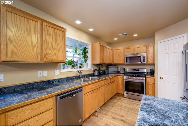 kitchen with light brown cabinets, light hardwood / wood-style floors, sink, and appliances with stainless steel finishes