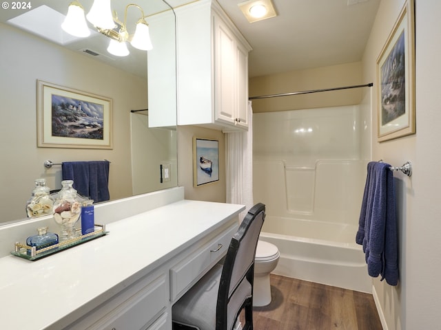 full bathroom with toilet, wood-type flooring, shower / bathing tub combination, vanity, and a notable chandelier