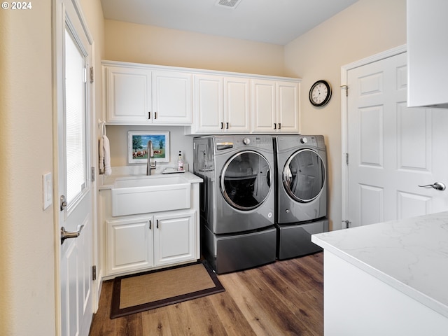 clothes washing area featuring sink, cabinets, dark hardwood / wood-style floors, independent washer and dryer, and a healthy amount of sunlight