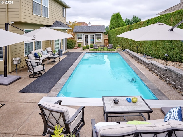 view of pool with an outbuilding, an outdoor living space, and a patio area