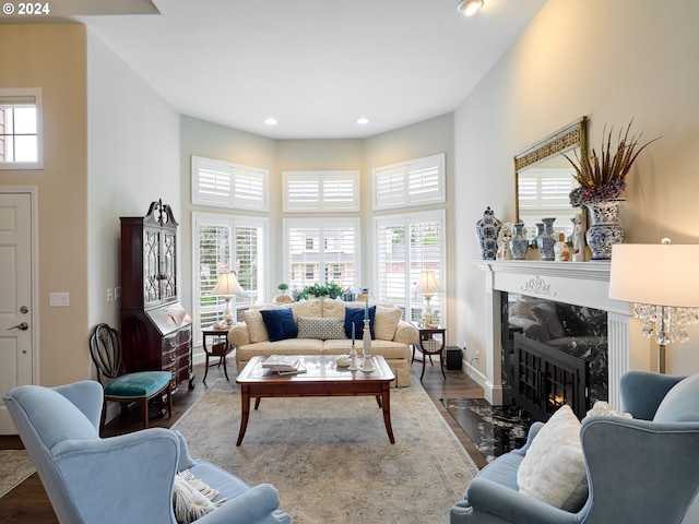 living room featuring hardwood / wood-style floors, a high end fireplace, and a high ceiling