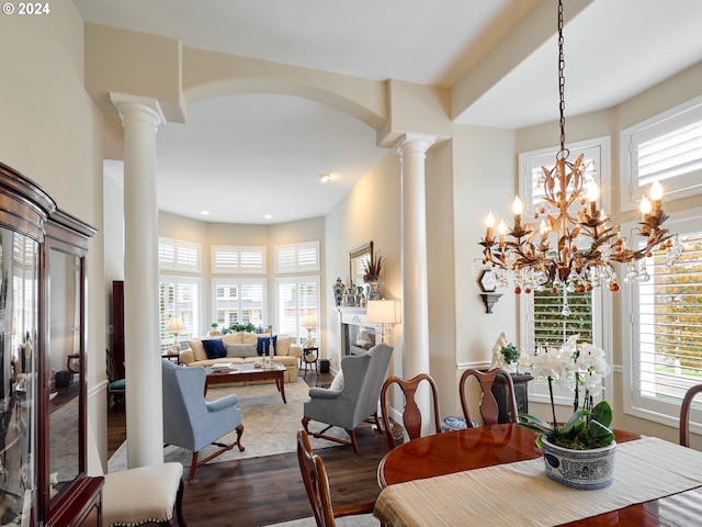 dining space with wood-type flooring and ornate columns