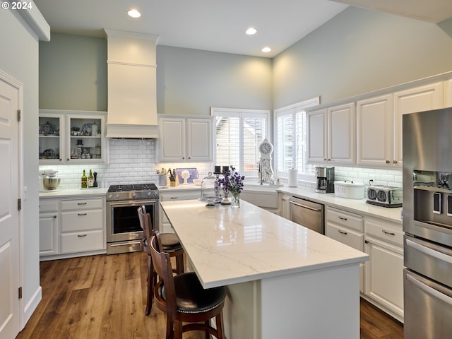 kitchen with white cabinetry, a breakfast bar, a center island, and appliances with stainless steel finishes