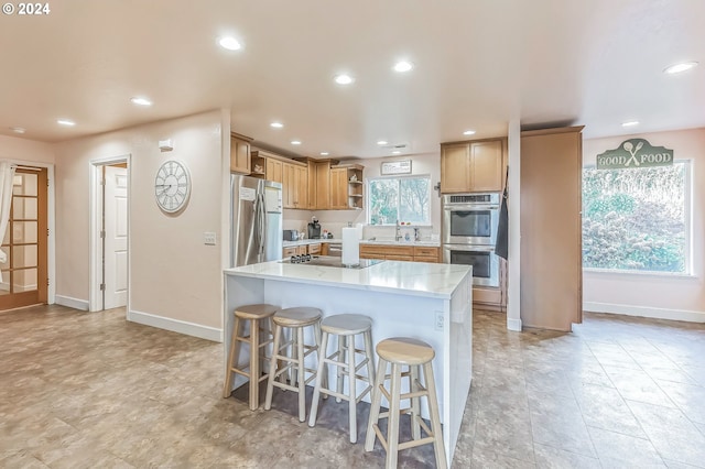 kitchen featuring a kitchen breakfast bar, a center island, and appliances with stainless steel finishes