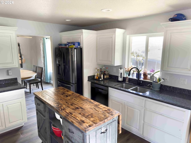 kitchen featuring black dishwasher, dark wood-type flooring, sink, and stainless steel refrigerator with ice dispenser