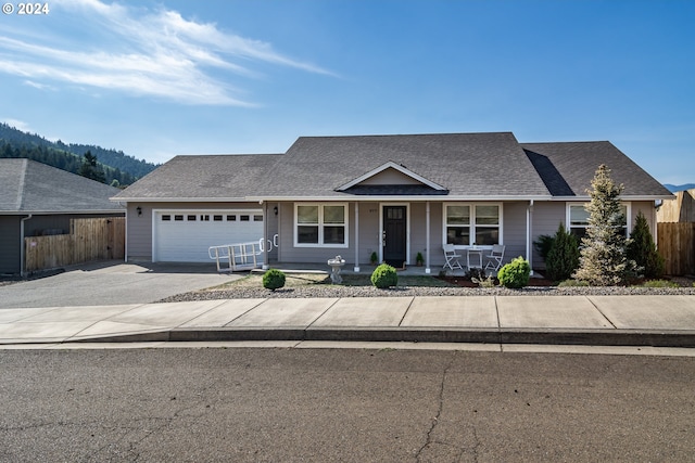 view of front of property featuring a garage, a porch, and a mountain view