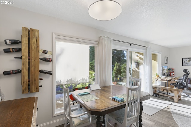 dining area with a textured ceiling and hardwood / wood-style flooring