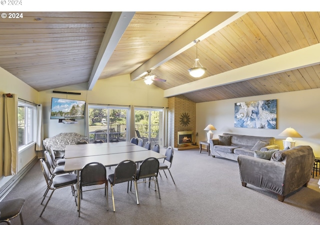 dining space featuring a brick fireplace, vaulted ceiling with beams, ceiling fan, carpet floors, and wood ceiling