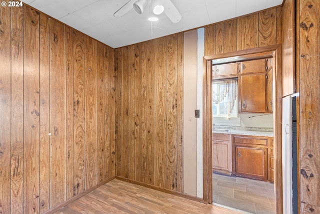 interior space featuring light wood-type flooring and wooden walls