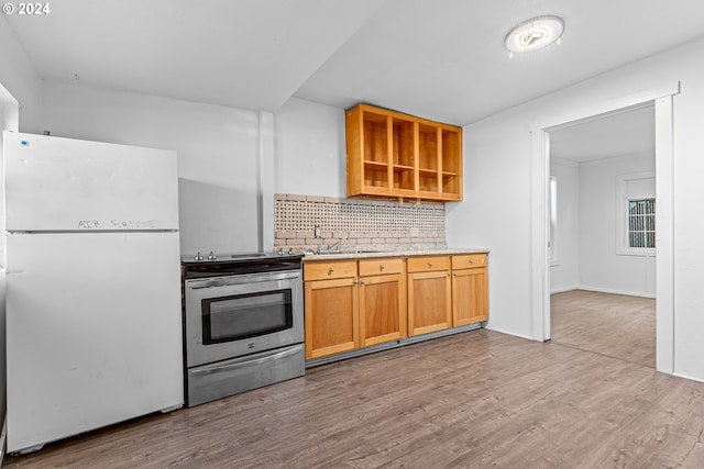 kitchen with stainless steel electric range, sink, light wood-type flooring, tasteful backsplash, and white fridge