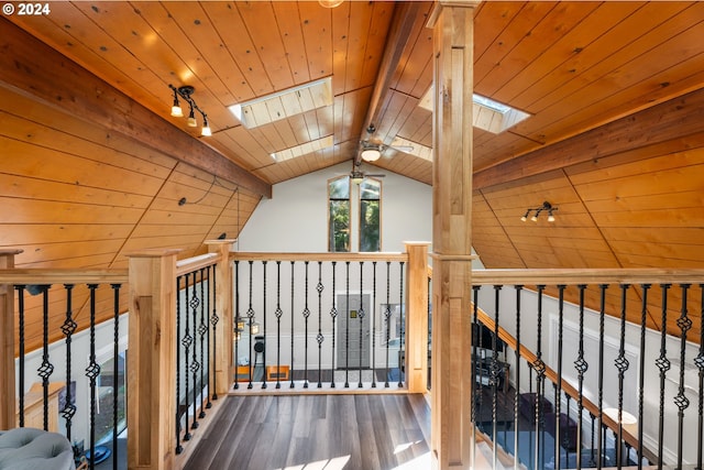 corridor with lofted ceiling with skylight, wooden ceiling, and wood finished floors