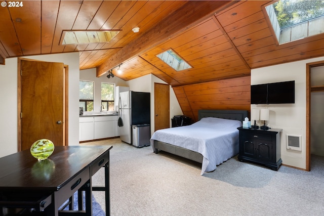 bedroom with vaulted ceiling with skylight, freestanding refrigerator, light carpet, heating unit, and wood ceiling