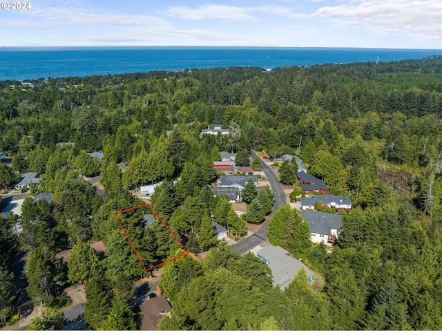 bird's eye view featuring a wooded view and a water view