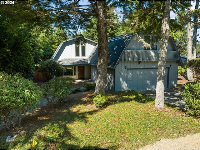 view of front facade featuring a garage, a shingled roof, a gambrel roof, driveway, and a front lawn