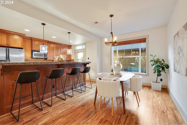 dining space with a chandelier and light wood-type flooring