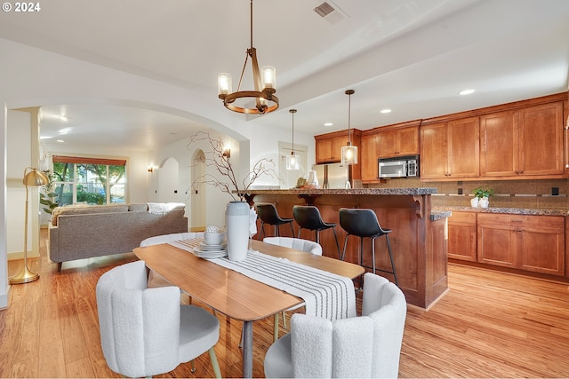 dining area featuring an inviting chandelier and light hardwood / wood-style flooring