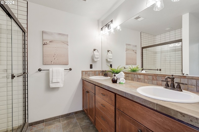 bathroom with a shower with shower door and vanity