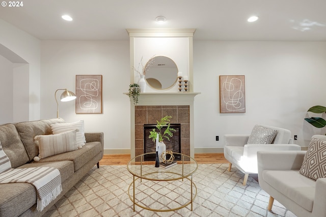 living room featuring light hardwood / wood-style flooring and a tile fireplace