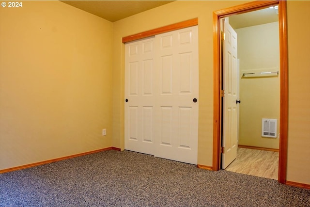 unfurnished bedroom featuring light colored carpet and a closet