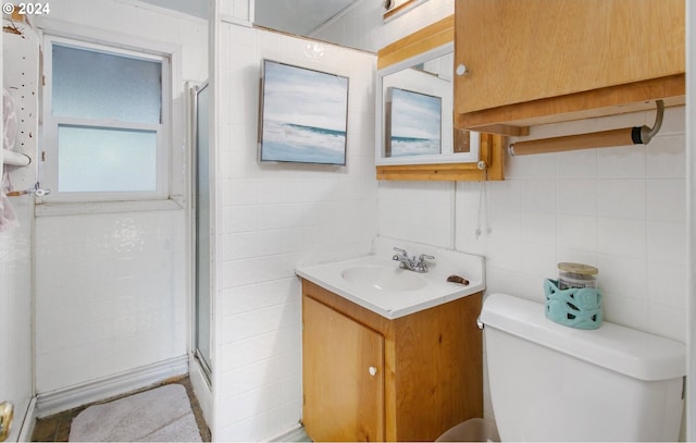 bathroom with vanity, toilet, and a shower with door