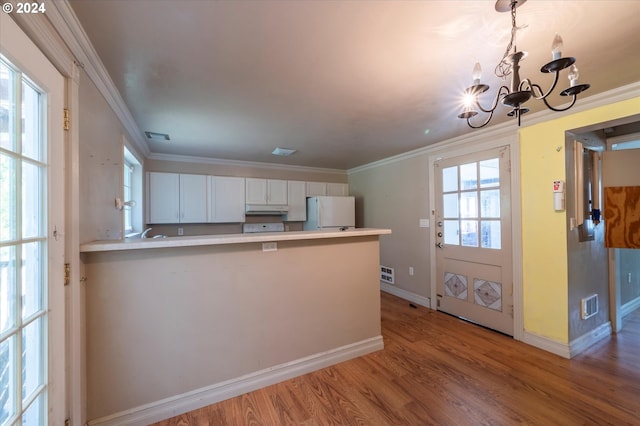 94213 Kerber Dr, Langlois, OR 97450 - kitchen featuring freestanding refrigerator, under cabinet range hood, a chandelier, light wood-style flooring, and ornamental molding