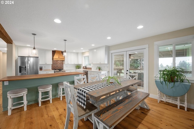 dining room with light wood-type flooring and french doors