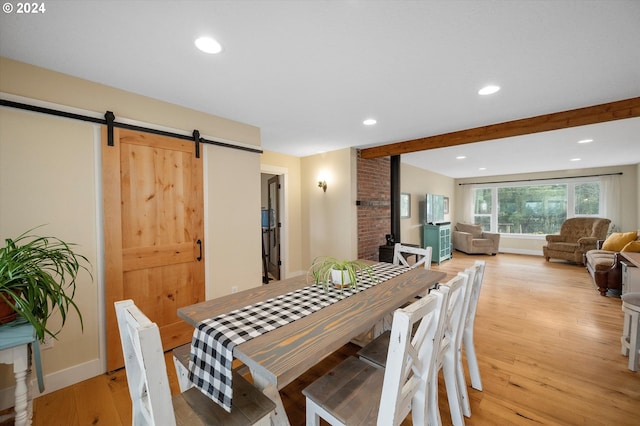 dining space featuring a barn door and light wood-type flooring